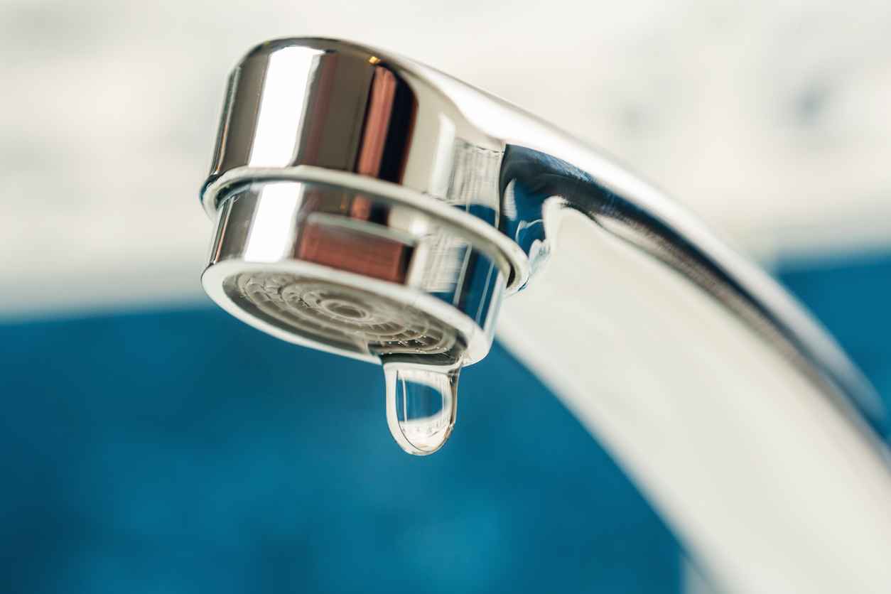 A drop of water drips from a leaky faucet.